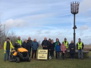 Group of people with the new tractor lawnmower and a sign that says pan Tod grass cutting in progress